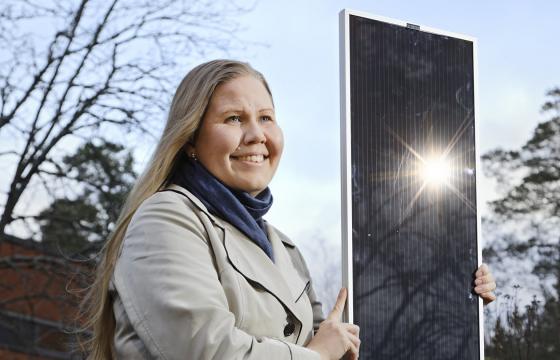 Kati Miettunen esittelee yksipuolista aurinkokennoa. Kaksipuoleinen kenno näyttää käytännössä samalta. 