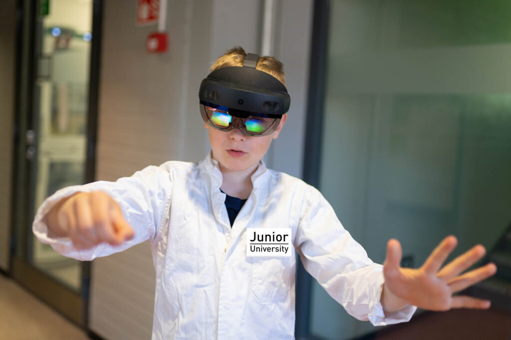 Lapsi laboratoriotakki päällä ja VR-lasit silmillä.