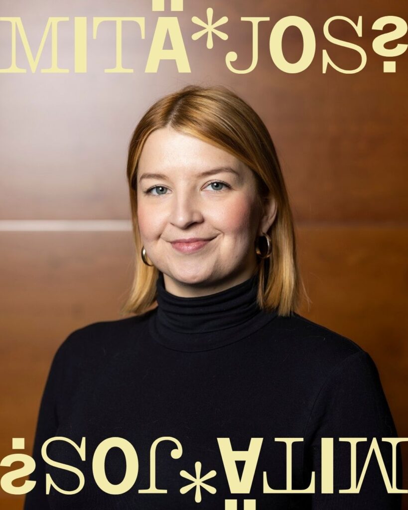 Vaaleahiuksinen nainen mustassa poolopaidassa.